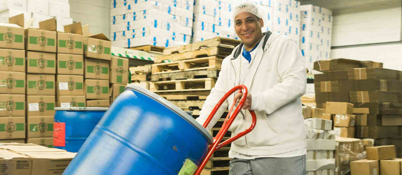 Food storage area with a man moving a large drum of liquid | food and beverage industry spills